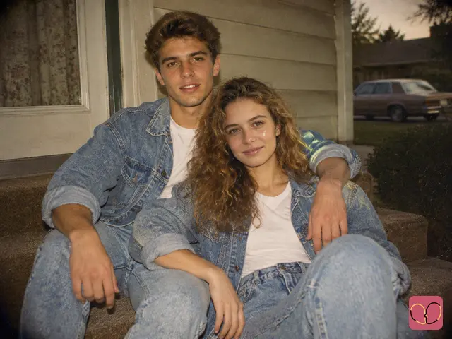 1980s couple photo - two people in matching double denim on the carpeted steps of a suburban house